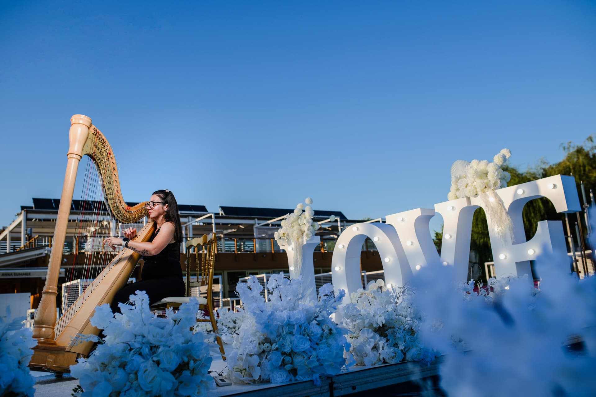 Harpista lângă literele LOVE, la ceremonie
